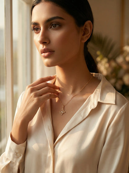 Woman wearing 18k gold plated  necklace in a softly lit room with a window in the background