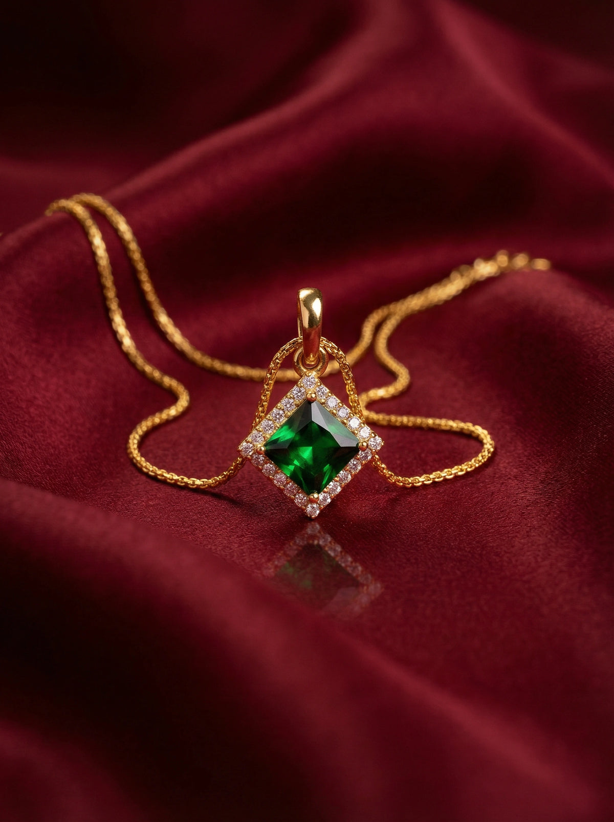 18k gold plated necklace with a green gemstone pendant on a red fabric background