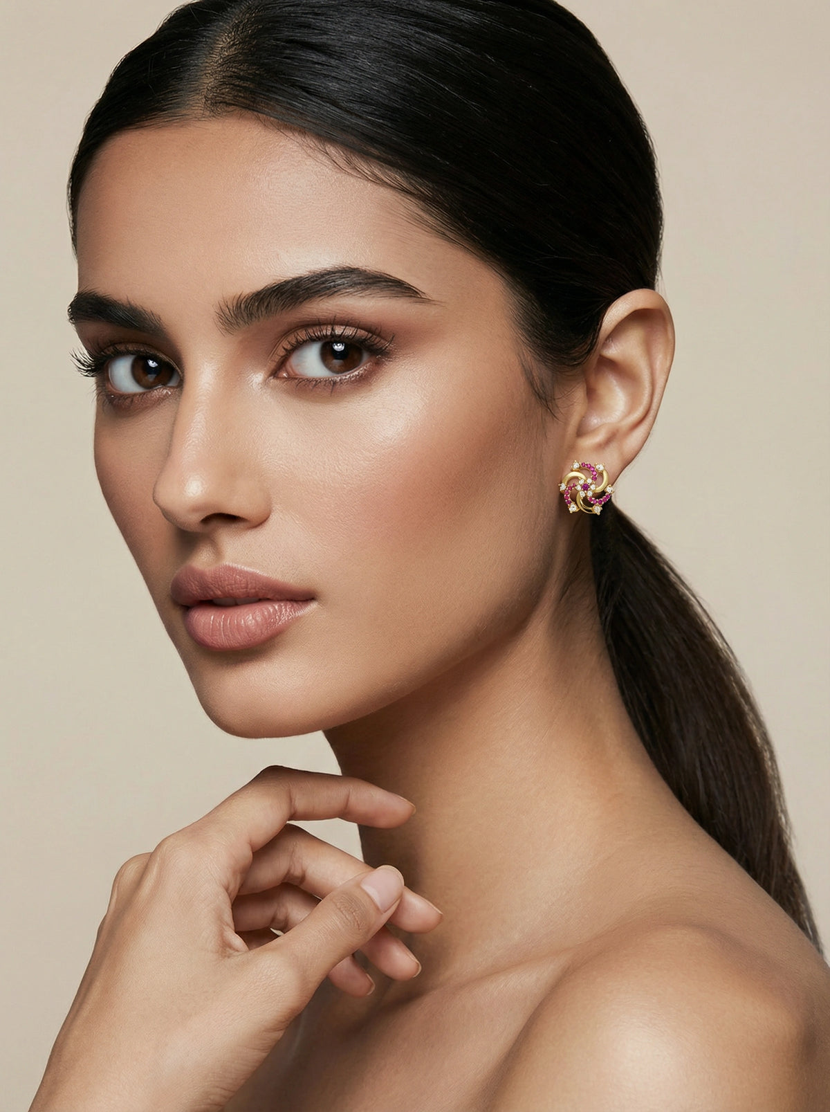 woman wearing 18k gold plated earrings with a neutral background