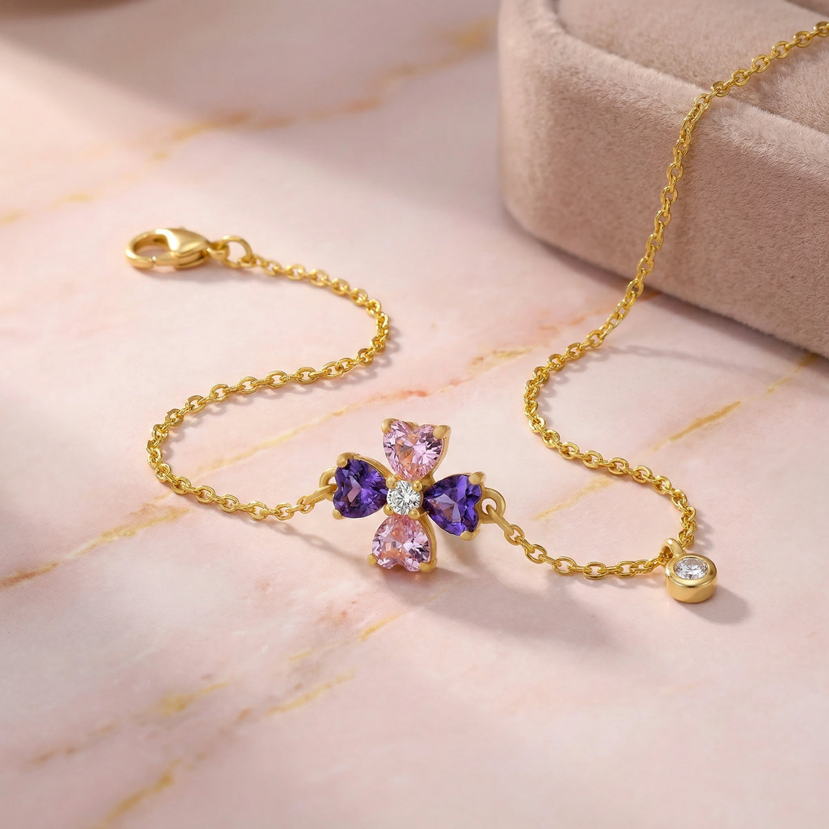 18k gold plated bracelet with colorful gemstones on a pink marble surface
