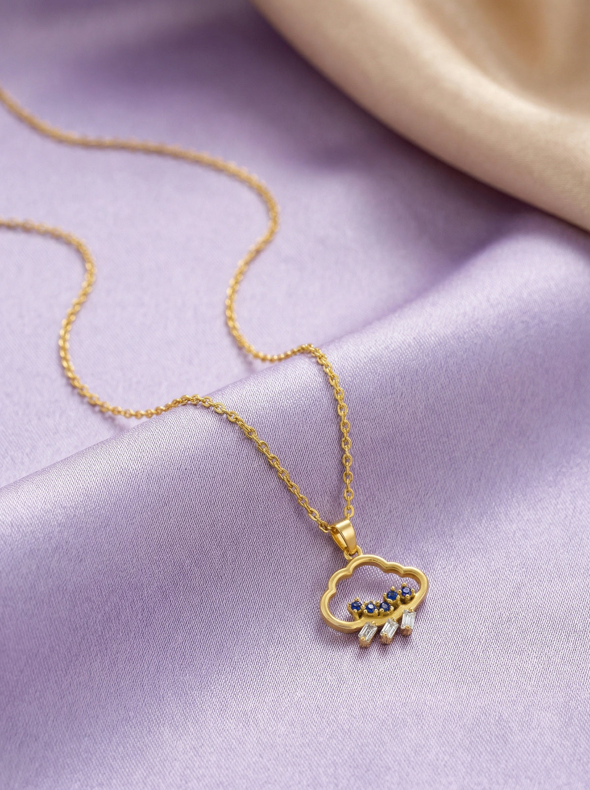 18k gold  plated necklace with a cloud-shaped pendant on a purple fabric background