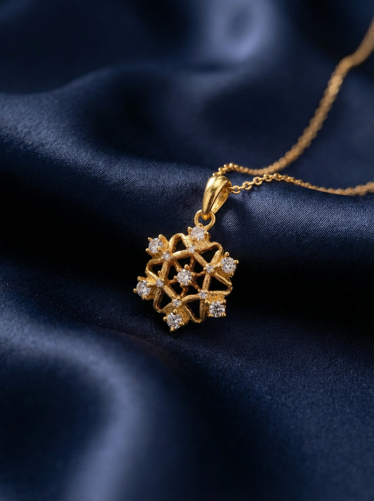 18k gold plated necklace with a diamond pendant on a dark blue fabric background