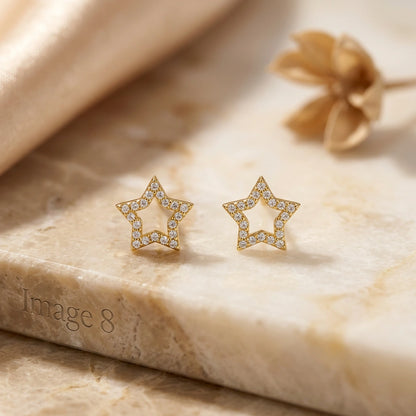 18k Gold plated star-shaped earrings with diamond accents on a marble surface.