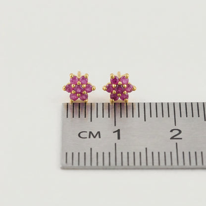 18k Gold plated earrings with pink gemstones next to a ruler for size reference on a white background