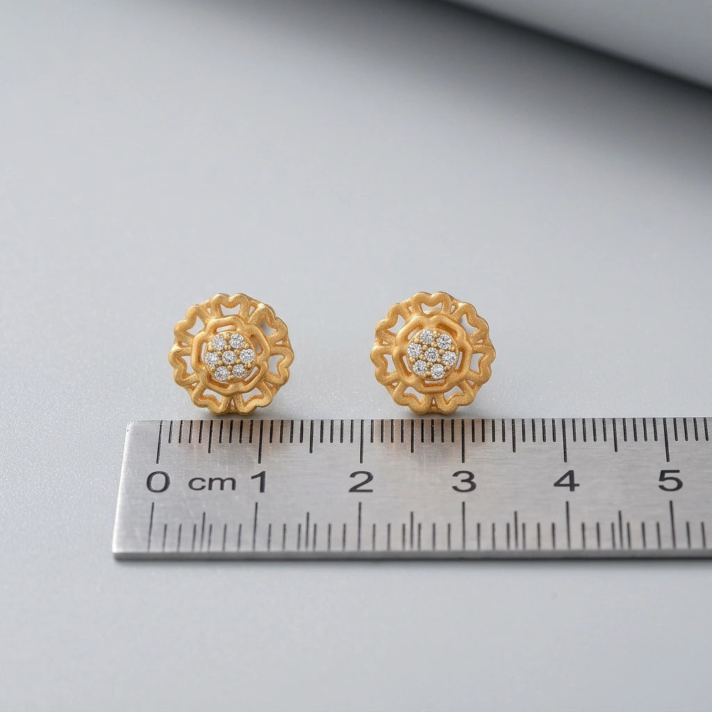 18k gold plated earrings with diamond accents on a gray surface next to a ruler for scale.