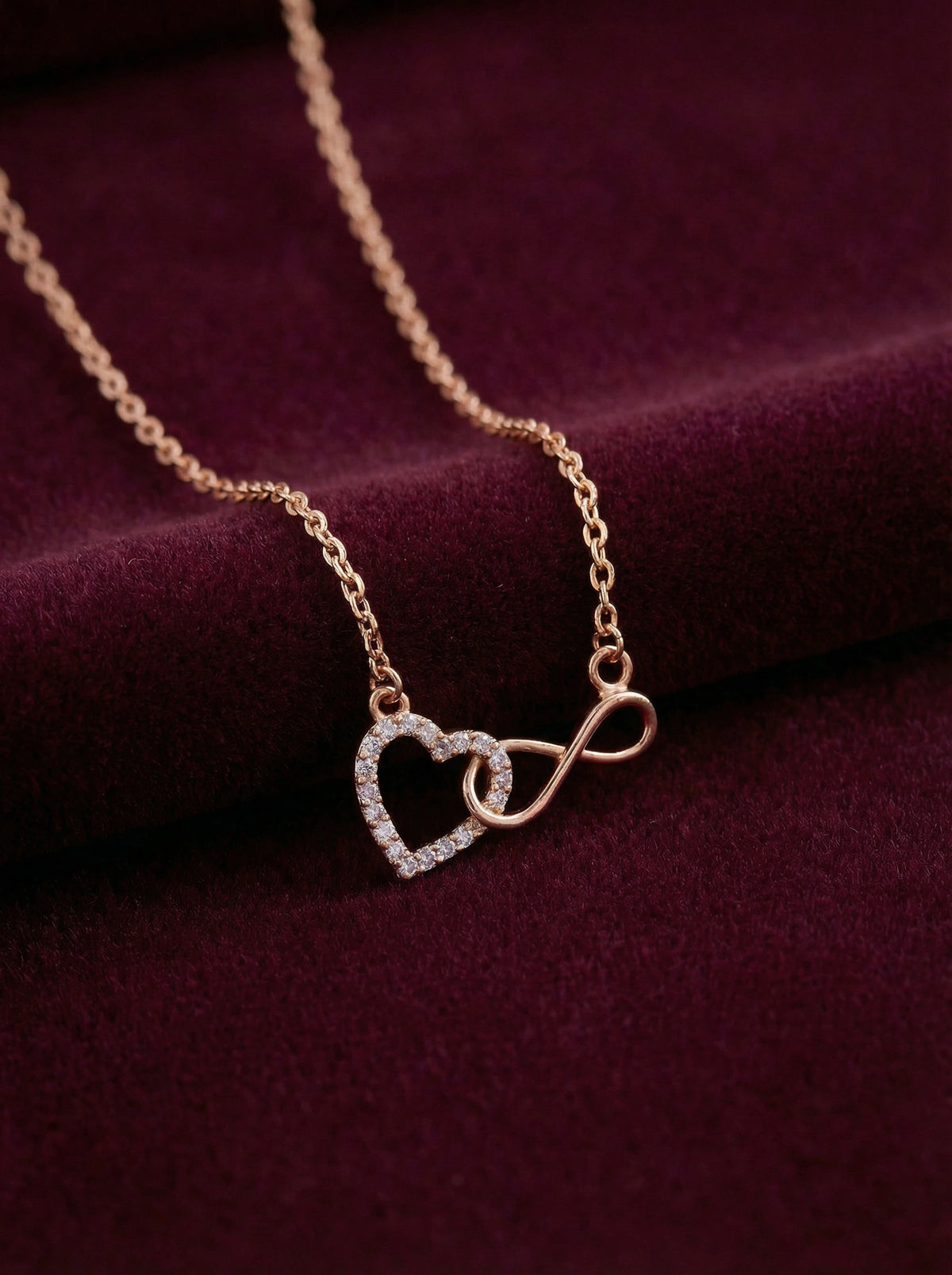 18k gold plated necklace with heart and infinity symbol pendant on a purple fabric background