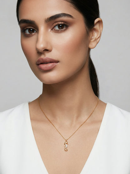 Woman wearing a 18k gold plated necklace with a unique pendant against a neutral background