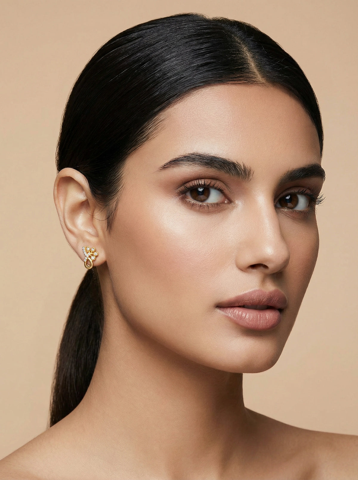 woman with a sleek ponytail against a beige background