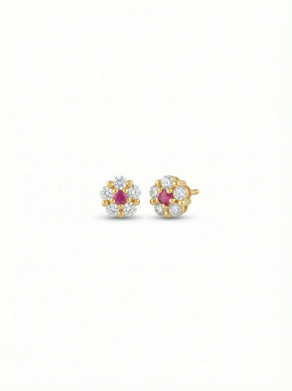 Pair of 18k gold plated earrings with ruby stones on a white background