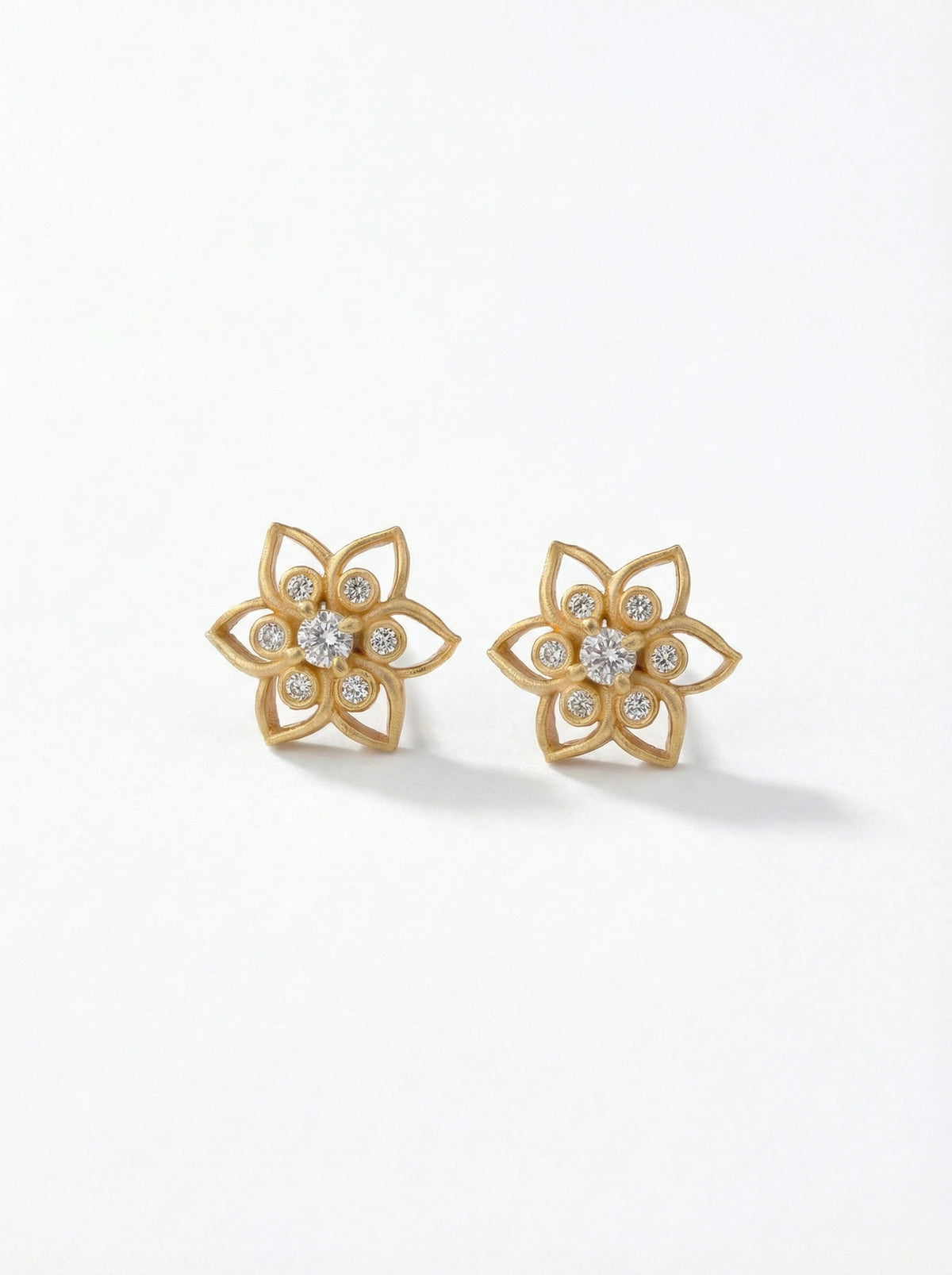 18k gold plated  flower-shaped earrings with clear stones on a white background