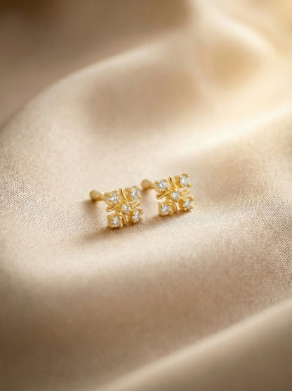 18k Gold plated earrings with gemstones on a beige fabric background