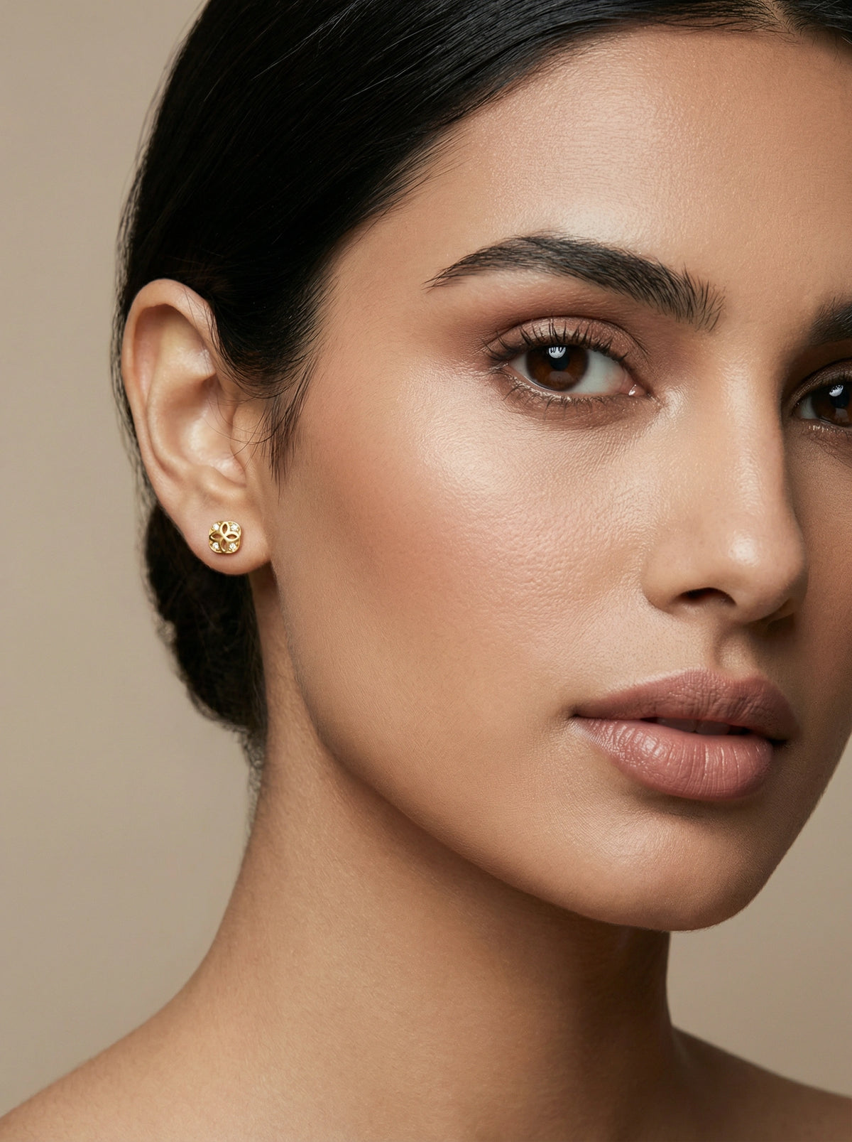 close-up of a woman's face with a neutral background  wear 18k gold plated white gemstone earing stud 