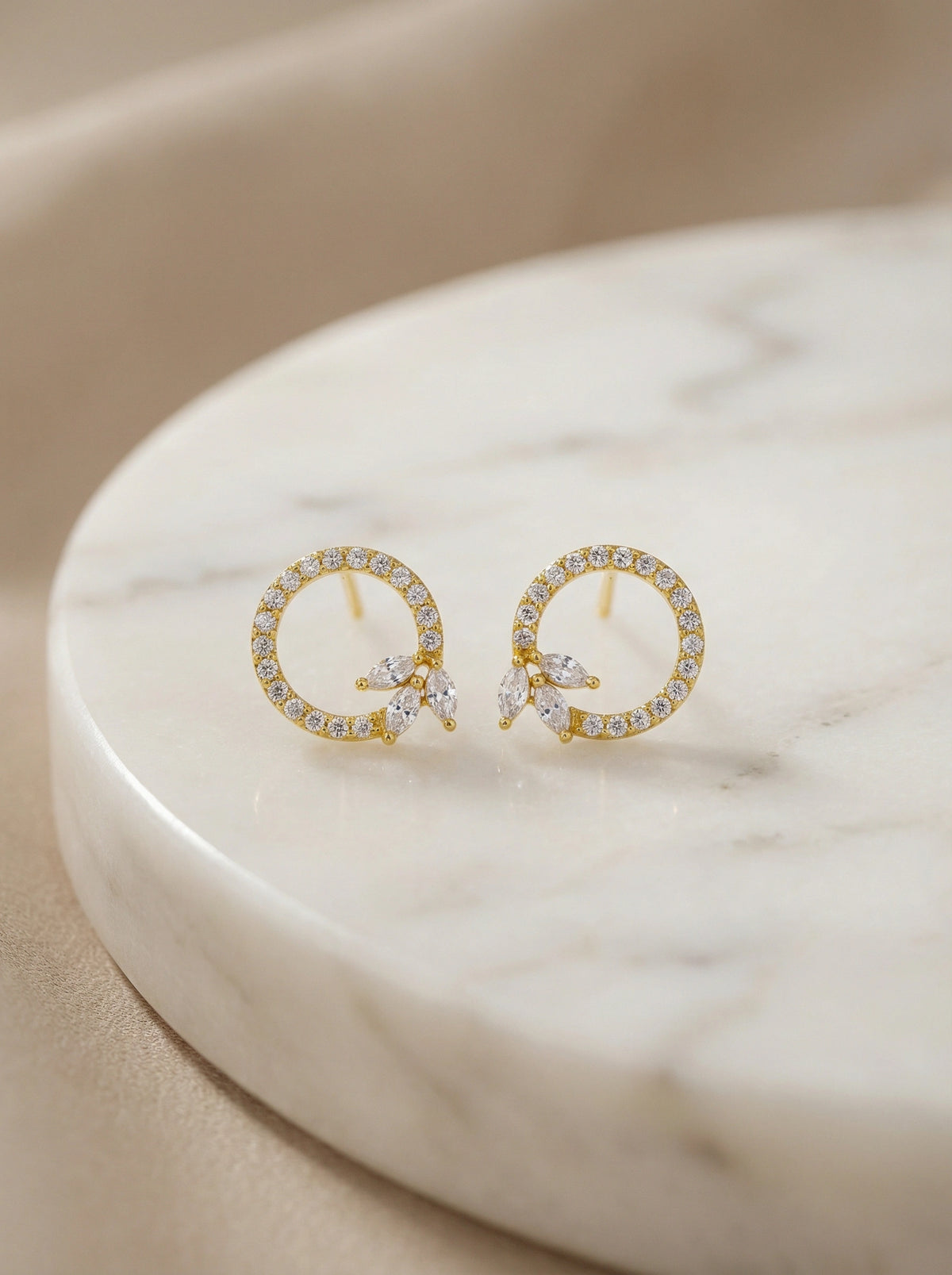 18k gold plated  earrings with small diamonds on a marble surface