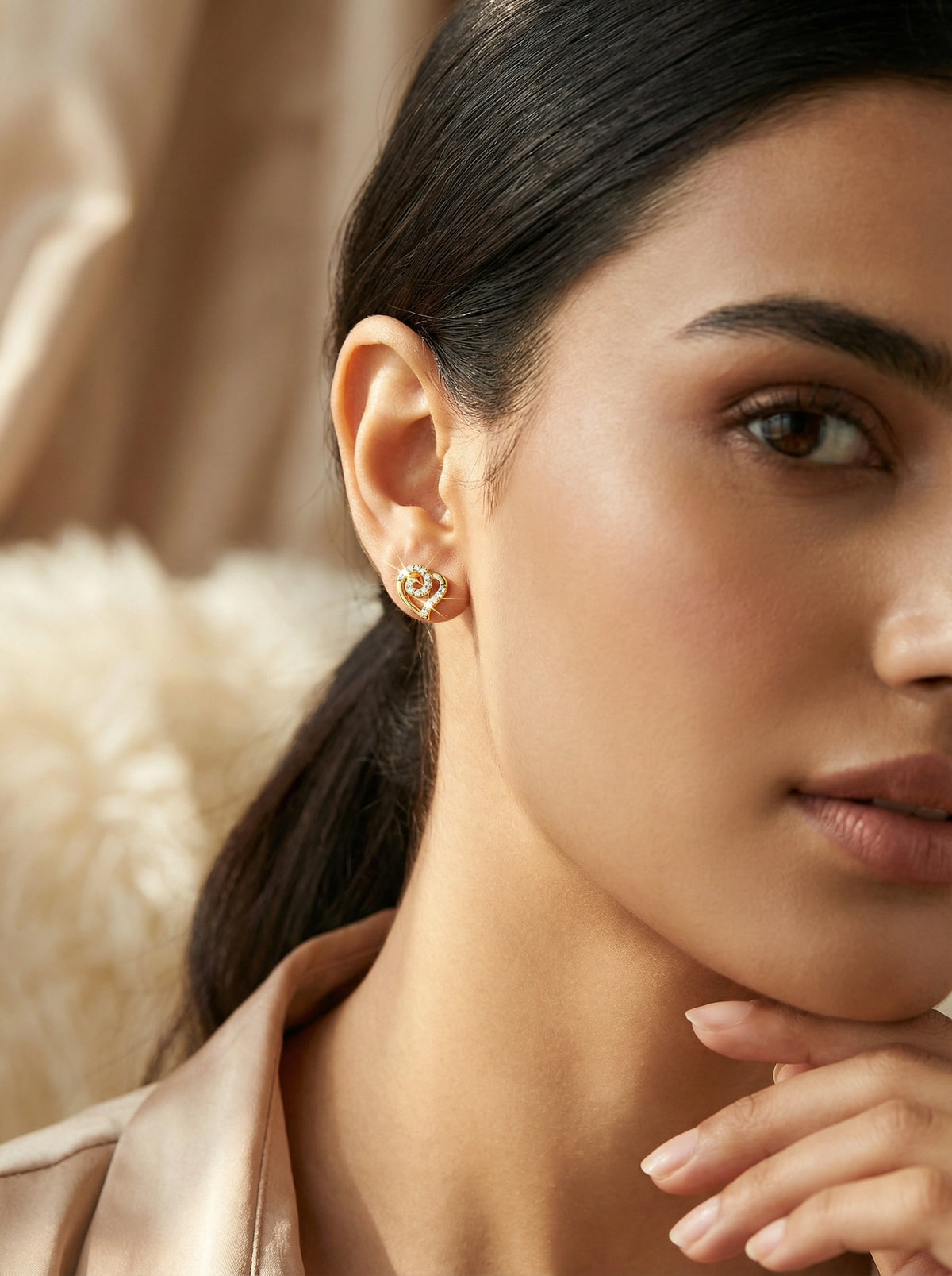 close-up of a woman wearing 18k gold plated earrings with a soft focus background