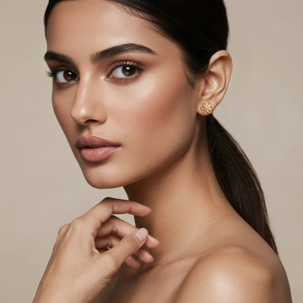 woman wearing 18k  gold plated heart-shaped earrings with a neutral background